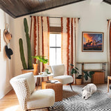Modern bedroom with wooden ceiling, striped rug, and decorative elements.