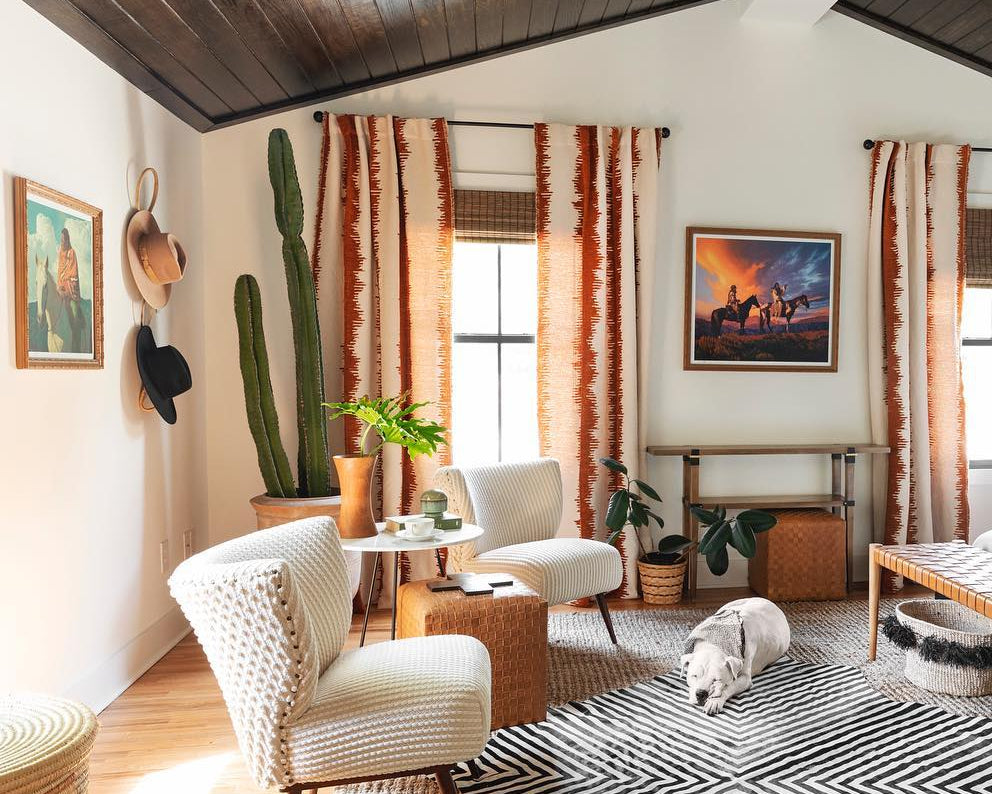 Modern bedroom with wooden ceiling, striped rug, and decorative elements.