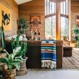 Living room with wooden walls, large windows, and decorative elements.